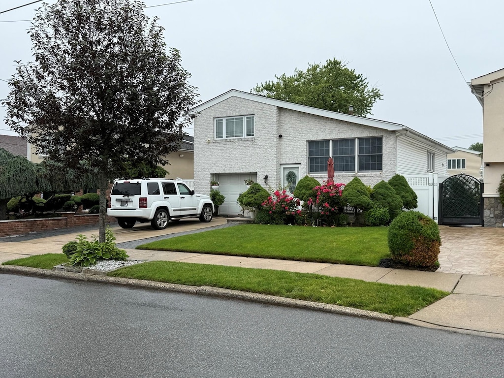 159-23 90th St, Howard Beach, NY 11414 - view of front of home with a garage, a gate, concrete driveway, and a front lawn