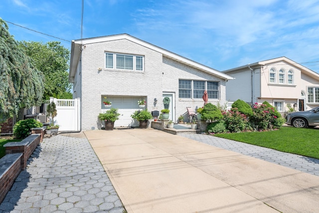159-23 90th St, Howard Beach, NY 11414 - split level home featuring brick siding, concrete driveway, an attached garage, and a gate