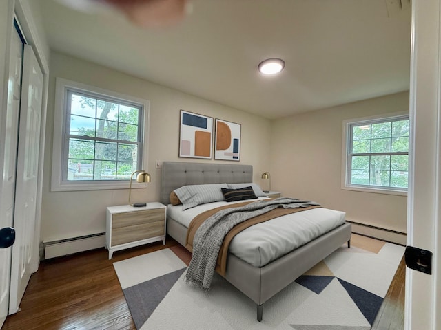 30 7th St, Holbrook, NY 11741 - bedroom with a baseboard heating unit, multiple windows, and dark wood finished floors