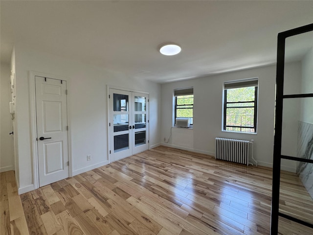 21528 47th Ave Unit 3B, Bayside, NY 11361 - unfurnished bedroom with radiator heating unit, light wood-style flooring, french doors, and cooling unit