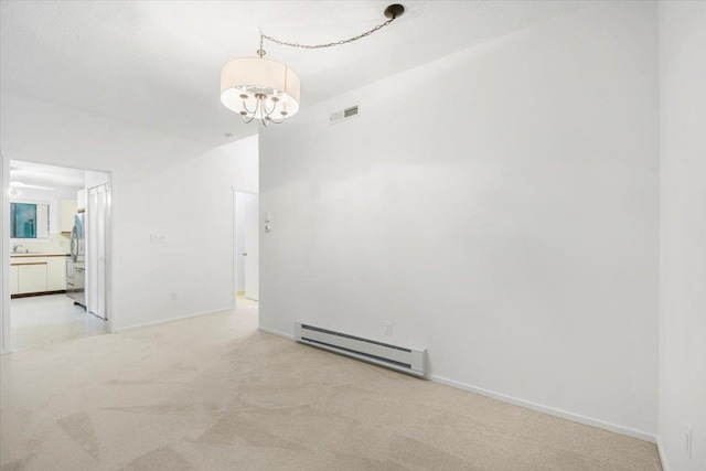 531 Heritage Hls Unit B, Somers, NY 10589 - spare room with a baseboard radiator, light carpet, and a chandelier