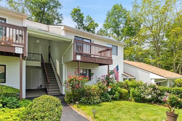 84 Molly Pitcher Ln Unit H, Yorktown Heights, NY 10598 - rear view of property featuring stairway, a balcony, and a lawn