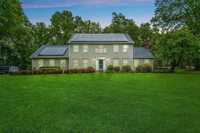 24 Hampton Ct, Wallkill, NY 12589 - colonial-style house featuring solar panels, a chimney, a front yard, and a storage unit