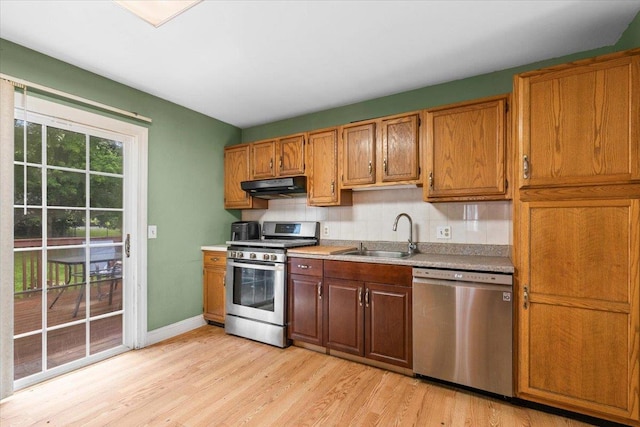76 Maureen Dr, Middletown, NY 10940 - kitchen featuring appliances with stainless steel finishes, extractor fan, light wood finished floors, backsplash, and light countertops