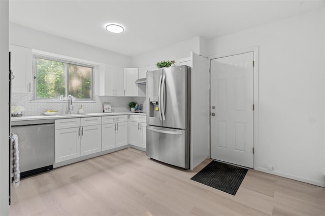 4 Westbrook Dr, Cortlandt Manor, NY 10567 - kitchen with stainless steel appliances, light wood-style flooring, white cabinets, backsplash, and light countertops