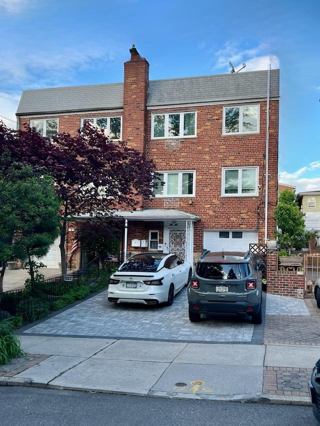 22-39 74th St, East Elmhurst, NY 11370 - view of front of home with driveway, brick siding, and a chimney