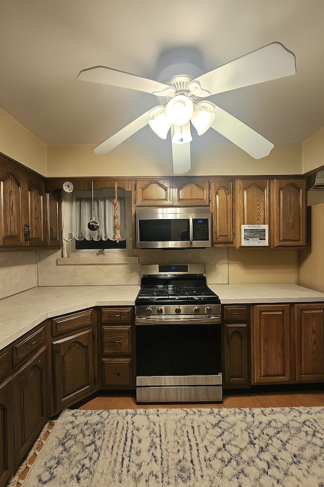 22-39 74th St, East Elmhurst, NY 11370 - kitchen featuring stainless steel appliances, light countertops, a ceiling fan, and dark brown cabinets