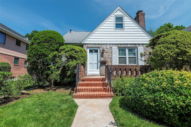147 Nugent St, New Hyde Park, NY 11040 - bungalow-style house featuring a chimney, a front yard, and brick siding