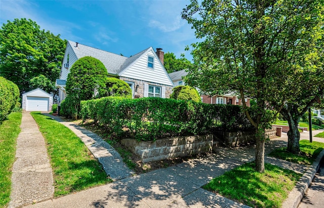 147 Nugent St, New Hyde Park, NY 11040 - view of front of home featuring driveway, a garage, an outbuilding, a chimney, and roof with shingles