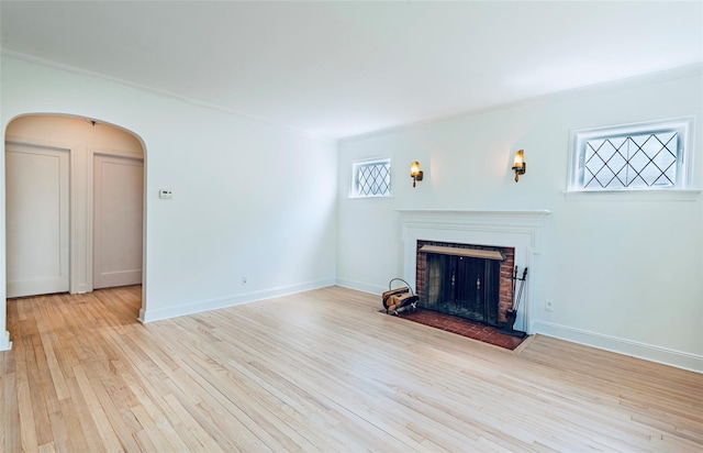 147 Nugent St, New Hyde Park, NY 11040 - unfurnished living room with crown molding, arched walkways, a fireplace, and wood finished floors