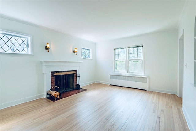 147 Nugent St, New Hyde Park, NY 11040 - unfurnished living room featuring radiator heating unit, healthy amount of natural light, wood finished floors, a brick fireplace, and crown molding