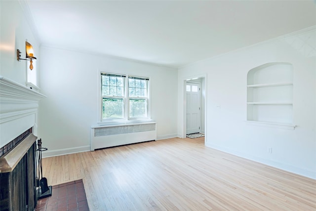 147 Nugent St, New Hyde Park, NY 11040 - unfurnished living room featuring wood finished floors, a fireplace with flush hearth, radiator, ornamental molding, and built in shelves