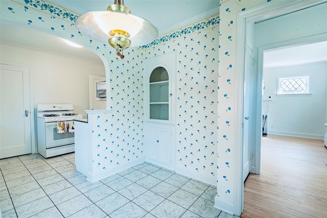 147 Nugent St, New Hyde Park, NY 11040 - kitchen with white range with gas stovetop, ornamental molding, arched walkways, and hanging light fixtures