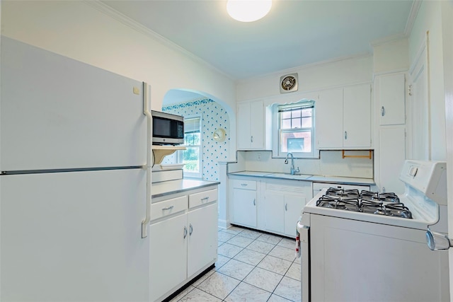 147 Nugent St, New Hyde Park, NY 11040 - kitchen featuring white appliances, crown molding, light countertops, white cabinets, and light tile patterned floors
