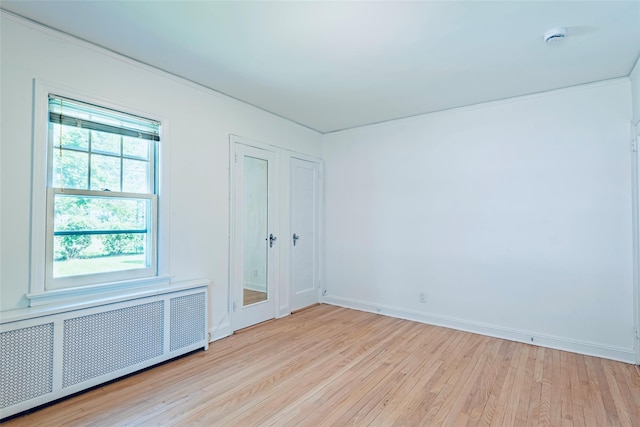 147 Nugent St, New Hyde Park, NY 11040 - empty room featuring radiator heating unit, light wood-type flooring, and a smoke detector