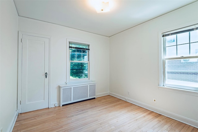 147 Nugent St, New Hyde Park, NY 11040 - empty room featuring radiator heating unit and light wood-style flooring