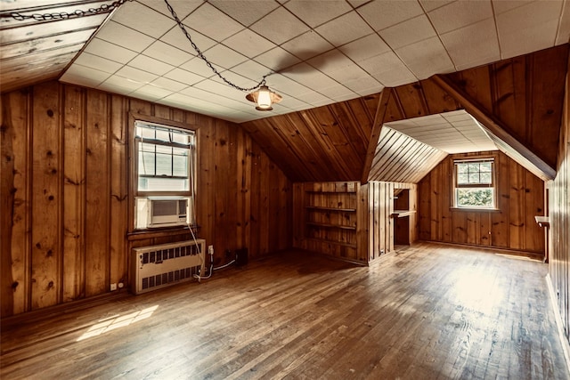 147 Nugent St, New Hyde Park, NY 11040 - bonus room featuring radiator heating unit, cooling unit, vaulted ceiling, hardwood / wood-style flooring, and wood walls