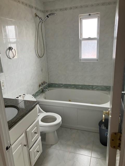 16330 95th St, Howard Beach, NY 11414 - full bath with tile walls, vanity, and shower / bathtub combination