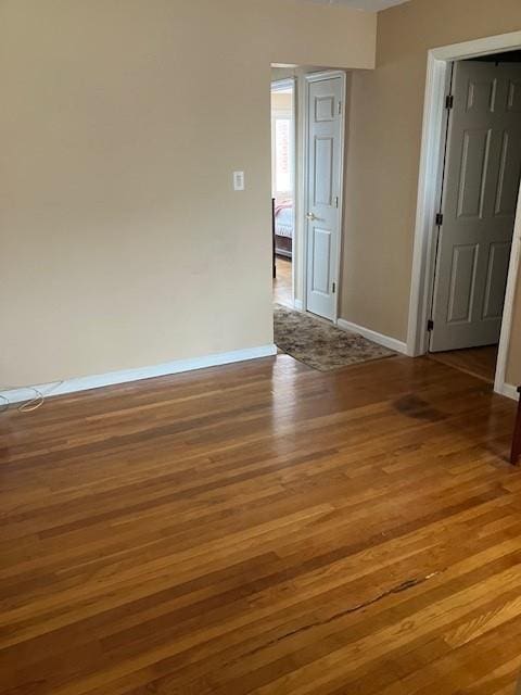 16330 95th St, Howard Beach, NY 11414 - spare room featuring wood finished floors and baseboards