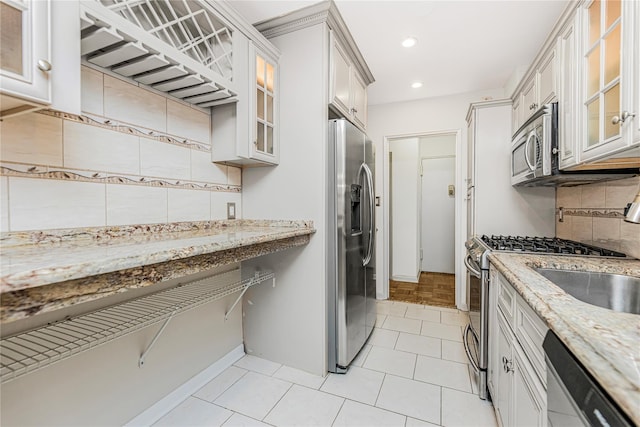 5550 Fieldstone Rd Unit 1C, Bronx, NY 10471 - kitchen featuring stainless steel appliances, tasteful backsplash, light stone counters, recessed lighting, and glass insert cabinets