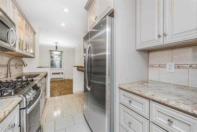 5550 Fieldstone Rd Unit 1C, Bronx, NY 10471 - kitchen with stainless steel appliances, radiator, tasteful backsplash, light stone counters, and recessed lighting