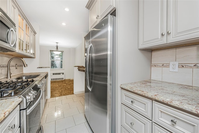 5550 Fieldstone Rd Unit 1C, Bronx, NY 10471 - kitchen featuring stainless steel appliances, radiator heating unit, backsplash, recessed lighting, and light stone counters