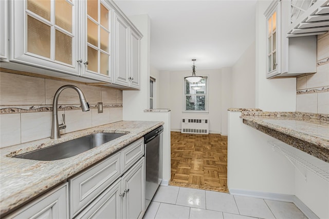 5550 Fieldstone Rd Unit 1C, Bronx, NY 10471 - kitchen with stainless steel dishwasher, radiator heating unit, backsplash, light stone counters, and glass insert cabinets