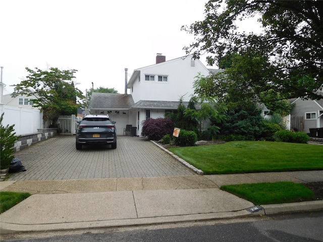 231 Willowood Dr, Wantagh, NY 11793 - view of front of home featuring driveway, a garage, and a chimney