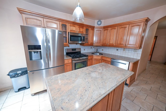5920 69th Pl, Maspeth, NY 11378 - kitchen featuring stainless steel appliances, arched walkways, tasteful backsplash, brown cabinetry, and decorative light fixtures
