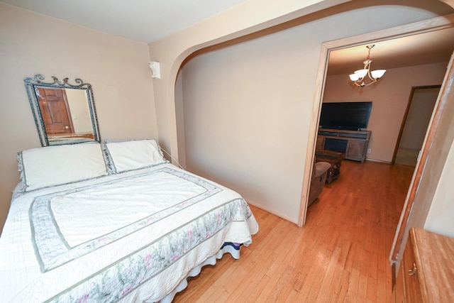 5920 69th Pl, Maspeth, NY 11378 - bedroom with arched walkways, a chandelier, and light wood-style flooring