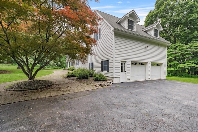 16 Apple Summit Ln, Lagrangeville, NY 12540 - view of side of property with asphalt driveway, a garage, a shingled roof, and a yard