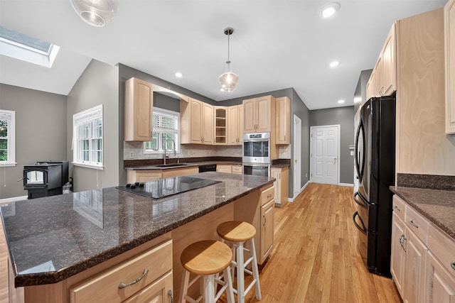16 Apple Summit Ln, Lagrangeville, NY 12540 - kitchen with black appliances, a breakfast bar, light wood-type flooring, a skylight, and lofted ceiling