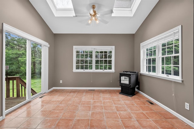 16 Apple Summit Ln, Lagrangeville, NY 12540 - unfurnished room with a skylight, a wood stove, lofted ceiling, light tile patterned flooring, and ceiling fan