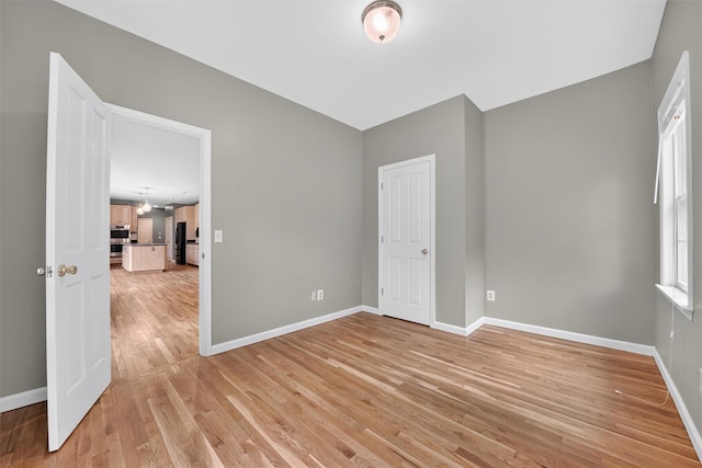16 Apple Summit Ln, Lagrangeville, NY 12540 - unfurnished bedroom with light wood-type flooring, freestanding refrigerator, and a chandelier