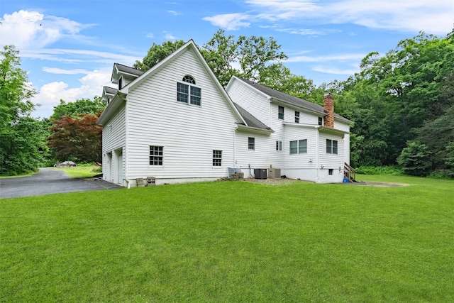 16 Apple Summit Ln, Lagrangeville, NY 12540 - back of property with a garage, a yard, asphalt driveway, and a chimney
