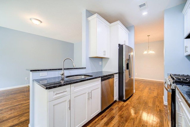 31 Pinto Rd W, Middletown, NY 10941 - kitchen with appliances with stainless steel finishes, dark wood-type flooring, white cabinetry, dark stone countertops, and a chandelier