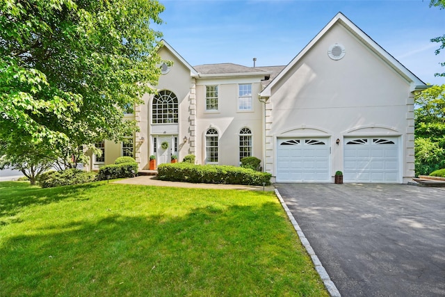 10 Inverness Ct, White Plains, NY 10605 - view of front of property with asphalt driveway, a front yard, stucco siding, and an attached garage