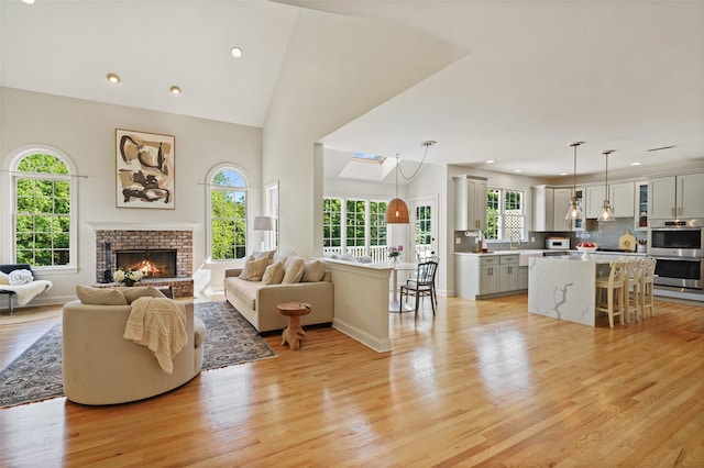 10 Inverness Ct, White Plains, NY 10605 - living area with light wood-style floors, recessed lighting, a brick fireplace, and high vaulted ceiling