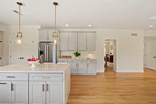 10 Inverness Ct, White Plains, NY 10605 - kitchen featuring stainless steel fridge, light wood-style flooring, hanging light fixtures, recessed lighting, and light stone countertops