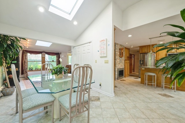 17 Piper Ln, Levittown, NY 11756 - dining area with a skylight, a stone fireplace, light tile patterned floors, high vaulted ceiling, and recessed lighting