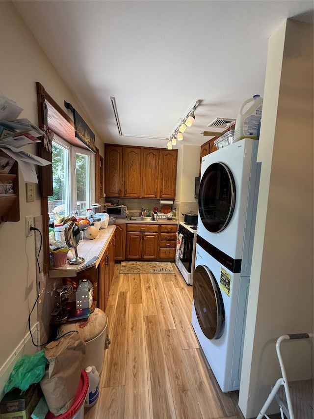 1016 Howells Rd, Bay Shore, NY 11706 - washroom featuring stacked washer / drying machine, light wood-style flooring, and attic access