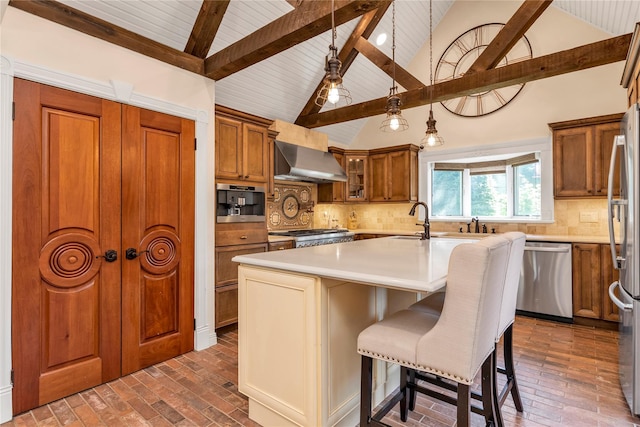 95 Falmouth Pl, Albertson, NY 11507 - kitchen featuring appliances with stainless steel finishes, wall chimney range hood, brown cabinetry, brick flooring, and light countertops