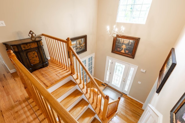 195 Bridle Way, Oakdale, NY 11769 - staircase featuring a chandelier, a towering ceiling, wood finished floors, and plenty of natural light
