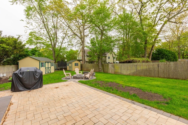 195 Bridle Way, Oakdale, NY 11769 - fenced backyard featuring a storage unit, an outdoor fire pit, a patio, and grilling area