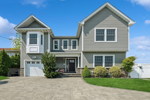 26 Island Pkwy N, Island Park, NY 11558 - view of front of home with stone siding, an attached garage, and decorative driveway