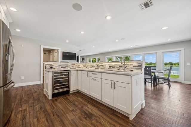26 Island Pkwy N, Island Park, NY 11558 - kitchen featuring wine cooler, stainless steel fridge, decorative backsplash, dark wood-style flooring, and recessed lighting