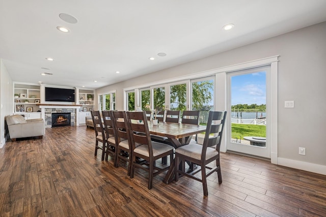 26 Island Pkwy N, Island Park, NY 11558 - dining room with plenty of natural light, dark wood finished floors, a fireplace, recessed lighting, and a water view