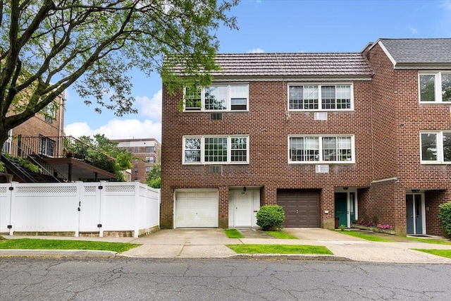 670 W 231st St, Bronx, NY 10463 - view of property with driveway, brick siding, and an attached garage