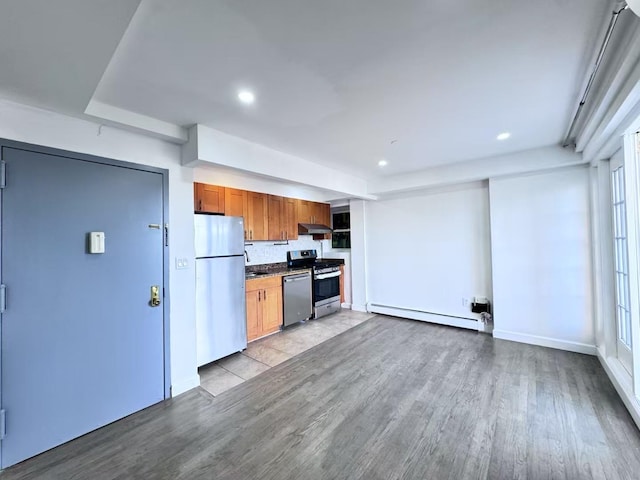 43-18 Robinson Unit 7C, Flushing, NY 11355 - kitchen with stainless steel appliances, a baseboard radiator, wood finished floors, recessed lighting, and tasteful backsplash
