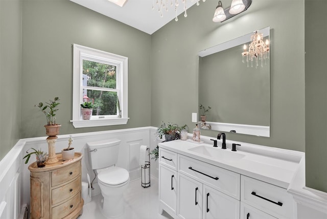 2300 State Route 207, Rock Tavern, NY 12575 - bathroom with a chandelier, vanity, a baseboard heating unit, and a wainscoted wall